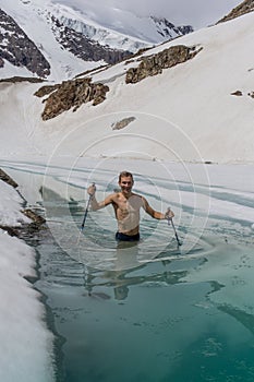 Young man bathing in the ice hole