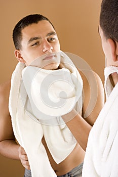 Young man in the bathroom's mirror after shaving