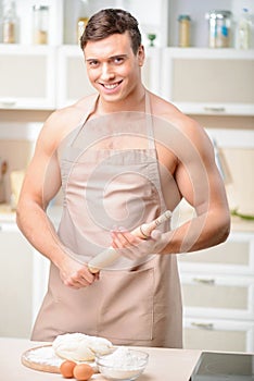 Young man with battledore beside counter table