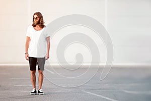 Young man with beard and long hair standing