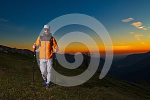 Young man with beard practicing nordic walking in a colorful sun