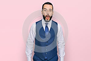 Young man with beard wearing business vest afraid and shocked with surprise expression, fear and excited face