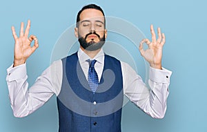 Young man with beard wearing business vest relax and smiling with eyes closed doing meditation gesture with fingers