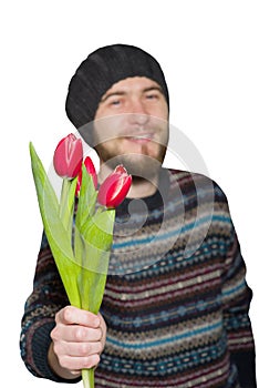A young man with a beard wearing a sweater and hat with red tulips