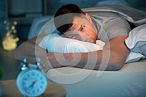 young man in bed with eyes opened suffering insomnia