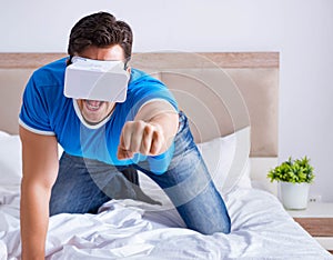 Young man in bed wearing a vr virtual reality head set