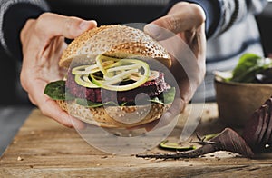 Young man with a beet burger sandwich