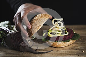 Young man with a beet burger sandwich