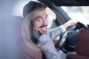 Successful man sitting behind the wheel of a prestigious car