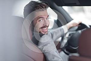 Successful man sitting behind the wheel of a prestigious car