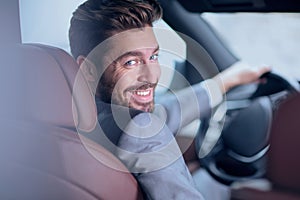 Successful man sitting behind the wheel of a prestigious car