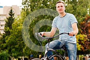 A young man on a bicycle looks into the distance