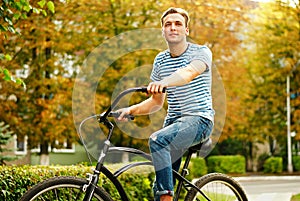 A young man on a bicycle looks into the distance