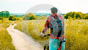 A young man on a bicycle looks into the distance,a sporty guy on a bicycle in nature,close-up.