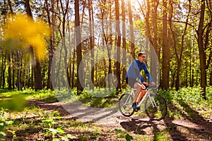 Young man bicyclist riding a road bike in spring forest