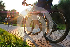 Young man on a bike in a city park at sunset close up. Active lifestyle concept