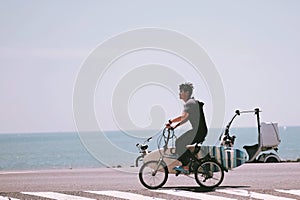 A young man biking to surf at the sea