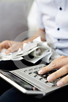 Young man with bills and calculator