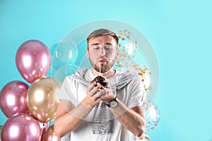 Young man with birthday muffin and air balloons