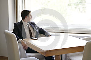 Young man in black business suit, white shirt and tie