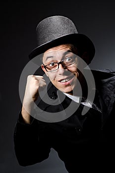 The young man in black coat and hat against gray