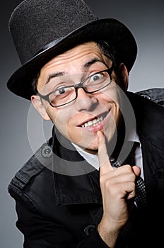 The young man in black coat and hat against gray