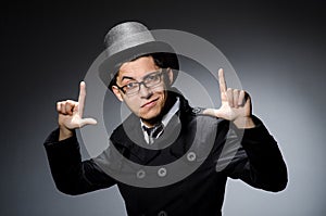 The young man in black coat and hat against gray