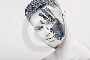 Young man with black hand print on white face. Closeup Portrait. Professional Fashion Makeup. fantasy art makeup