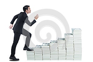 The young man in black suite is walking on stack of banknote like up stair