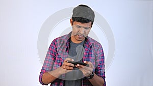 A young man in a black tshirt is celebrating his victory in a racing game on his mobile phone