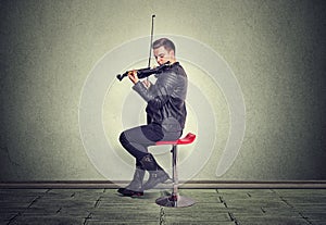 Young man on black wooden violin