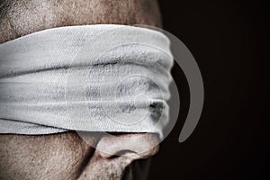 Young man with a blindfold in his eyes photo