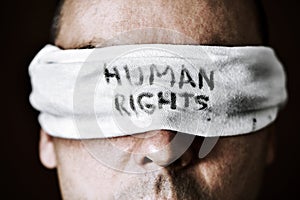 Young man with a blindfold with the text human rights