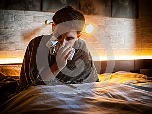 Young man blowing his nose with handkerchief