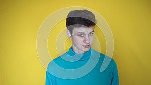 Young man in blue clothes facial expressions. Boy teenager turns head from side seeking something and throwing up his