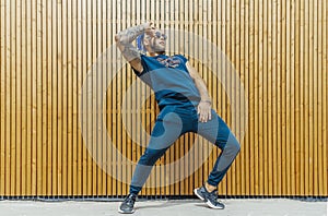 Young man with blue dreadlocks dancing reggaeton in the street.