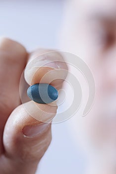 Young man with a blue pill