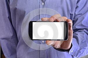 Young man in a blue shirt is holding a phone with the white scre