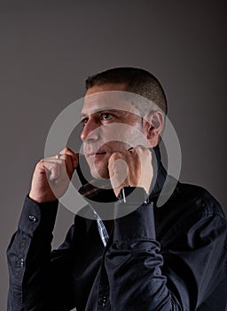 Young man in blue shirt posing in studio