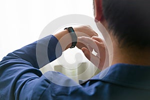 Young man in blue suit checking his wristband