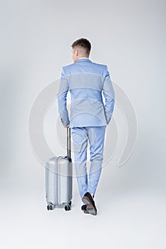 Young man in blue suit with suitcase