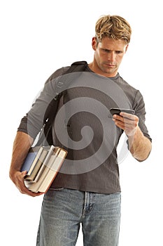 Young man with books and backpack on cell phone