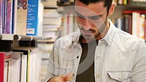 Young man in bookstore or library leafing through book