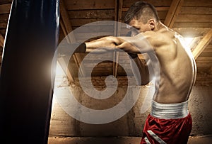 Young man boxing, exercise in the attic