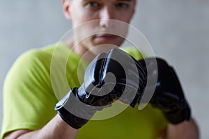 Young man in boxing gloves indoors