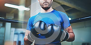 Young man in boxing gloves. Young Boxer fighter over blurred background.Boxing man ready to fight. Boxing, workout