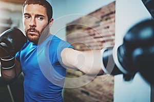 Young man boxing workout in fitness gym on blurred background.Athletic man training hard.Kick boxing concept.Horizontal.