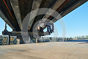 Young man break dancer doing somersault acrobatic stunts dancing on urban background