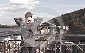 Young man on a bridge in a big city