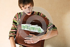 Young man with briefcase full of money